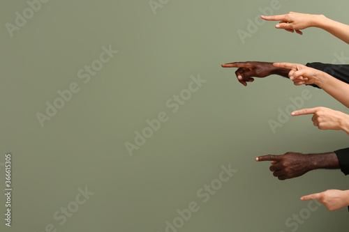 Hands of Caucasian women and African-American man showing something on color background. Racism concept photo