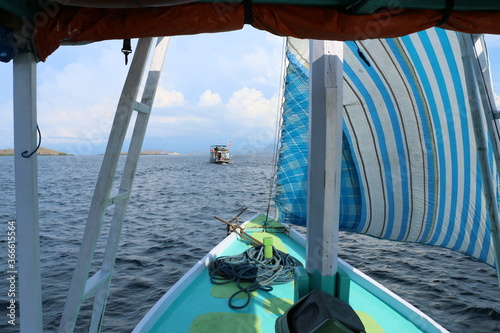 view over front sail of sailing boat and ocean with boat in the front, Komodo Islands, Indonesia