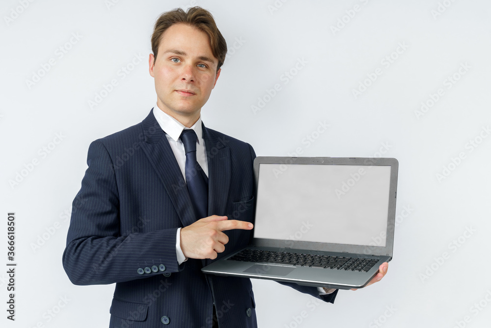 A businessman holds a laptop, the other hand shows the screen. White background A businessman holds a laptop, the other hand shows the screen. White background