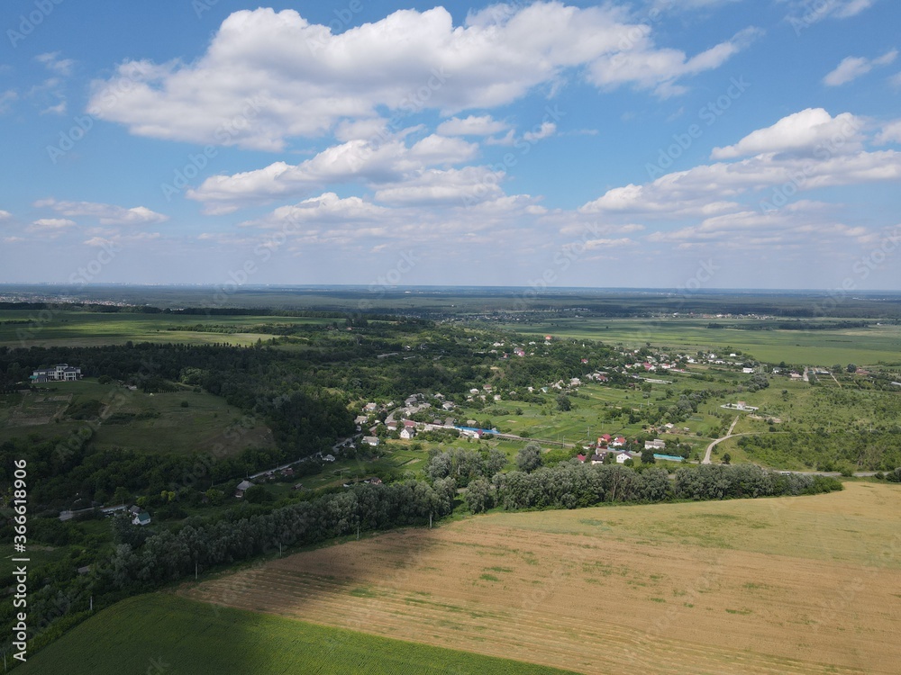Aerial view of yellow and green fields in summer with blue sky and white clouds Aerial view of yellow and green fields in summer with blue sky and white clouds