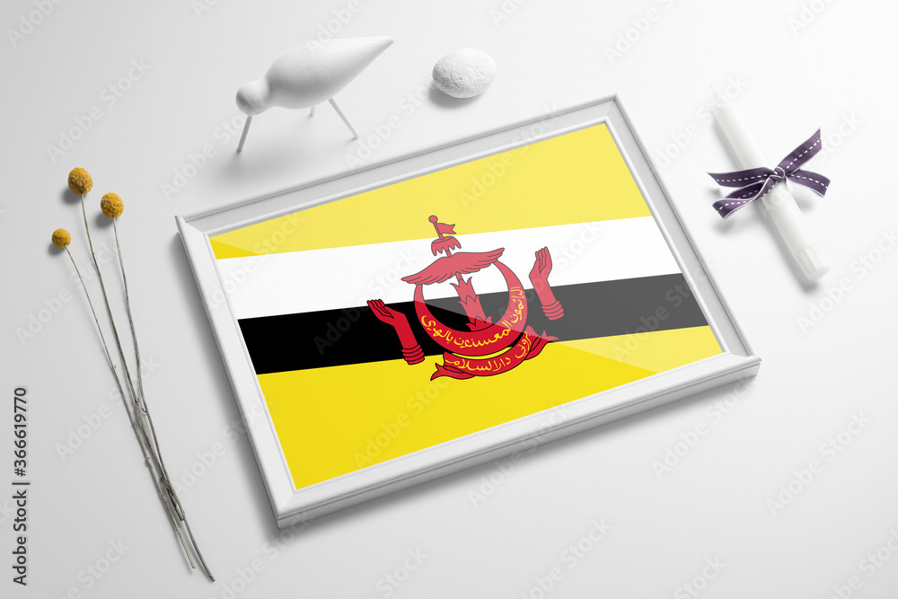 Brunei flag in wooden frame on table. White natural soft concept, national celebration theme. Brunei flag in wooden frame on table. White natural soft concept, national celebration theme.