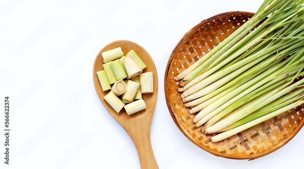 Lemongrass slices on wooden spoon with fresh lemongrass in wooden bamboo threshing basket on white background. Lemongrass slices on wooden spoon with fresh lemongrass in wooden bamboo threshing basket on white background.