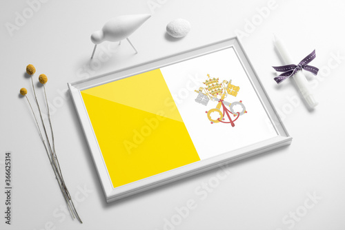 Vatican City flag in wooden frame on table. White natural soft concept, national celebration theme.