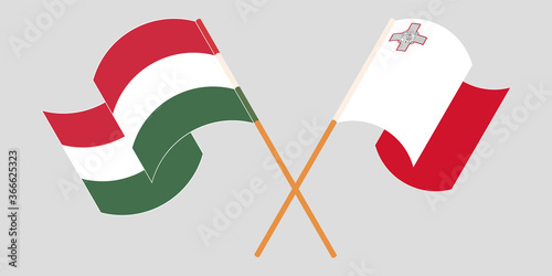 Crossed and waving flags of Malta and Hungary