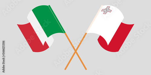 Crossed and waving flags of Malta and Italy