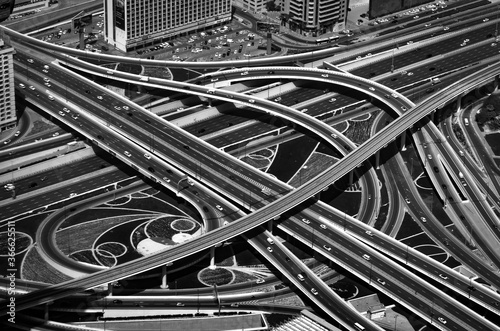 Junction roads viewed from above. Traffic on the highway in Dubai downtown, UAE. Abstract black and white photo with high contrast.