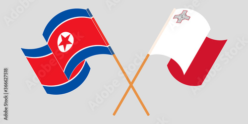 Crossed and waving flags of Malta and North Korea