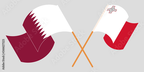Crossed and waving flags of Malta and Qatar