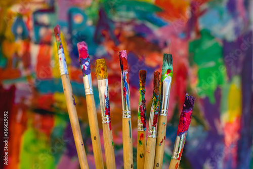 Art brushes on the abstract palette of acrylic paints background