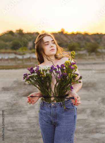 Girl with long hair with flowers at sunset