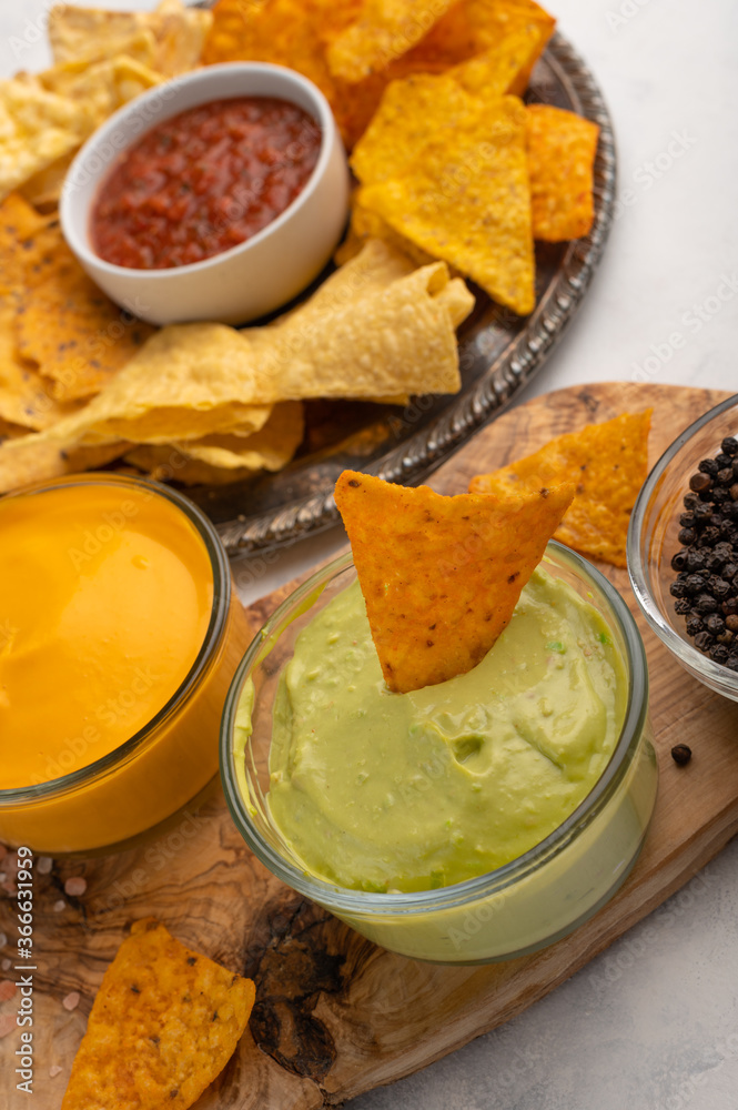 Chips and snacks with avocado and dip sauce, close-up top view