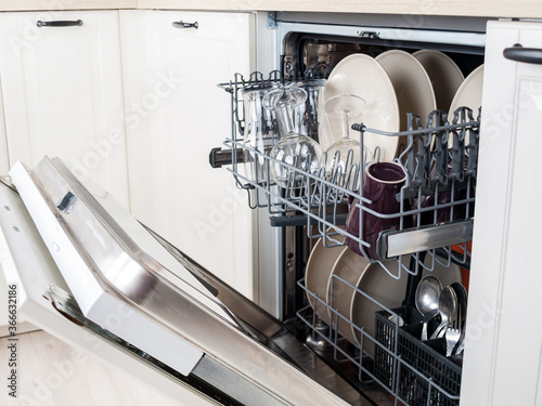 dishwasher close-up with washed dishes, easy to use and save water, eco-friendly, built-in kitchen dish washing machine