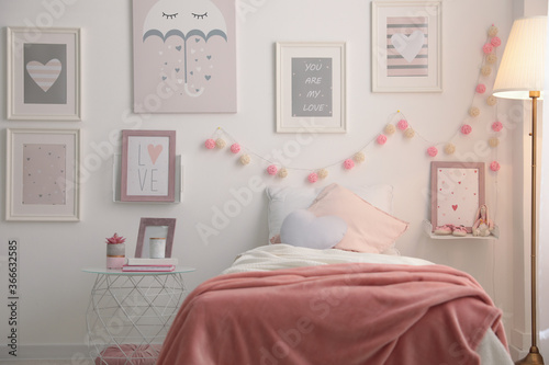 Stylish child's room interior with beautiful pictures and comfortable bed © New Africa