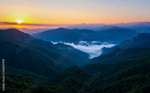 Mountain landscape in the early morning with the sun behind the clouds