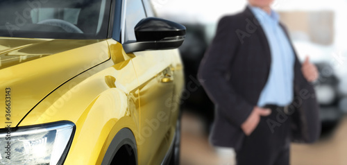 Customer choosing and buying car in auto dealership, focus on new auto. Banner design © New Africa