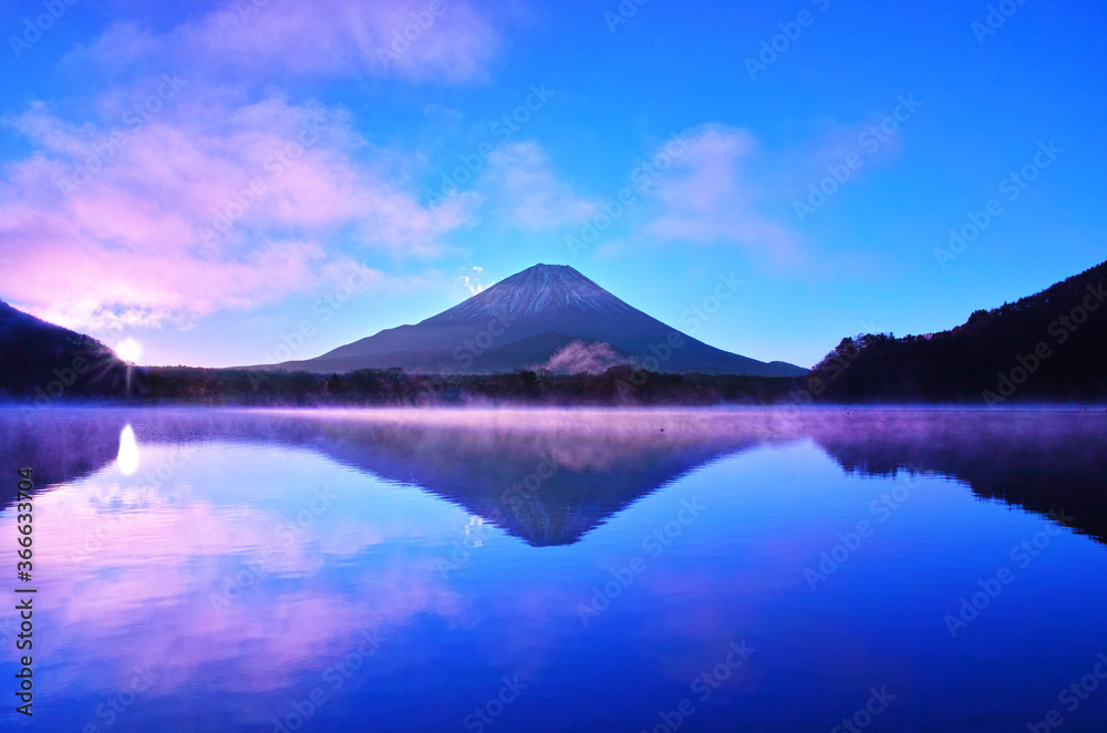 晩秋の日の出を迎えた精進湖。気嵐が立ち上る湖面と富士山
