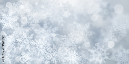 Christmas background of blurry snowflakes in gray colors