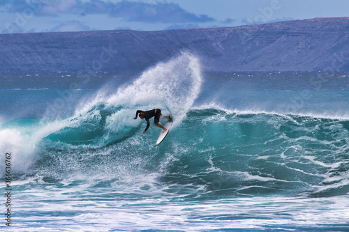 High energy surfer on an action packed big wave on the island of Maui.
