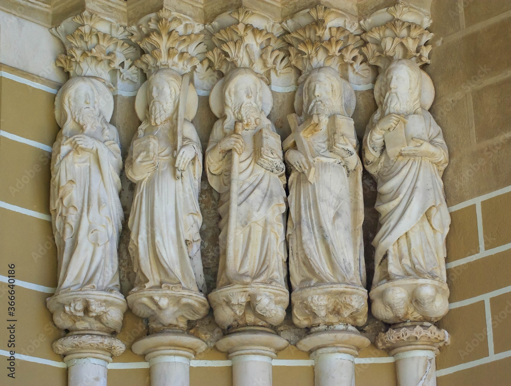 Five of the twelve apostles in natural light outside the main door of a fourteenth century gothic Sé Cathedral in Évora, Portugal.