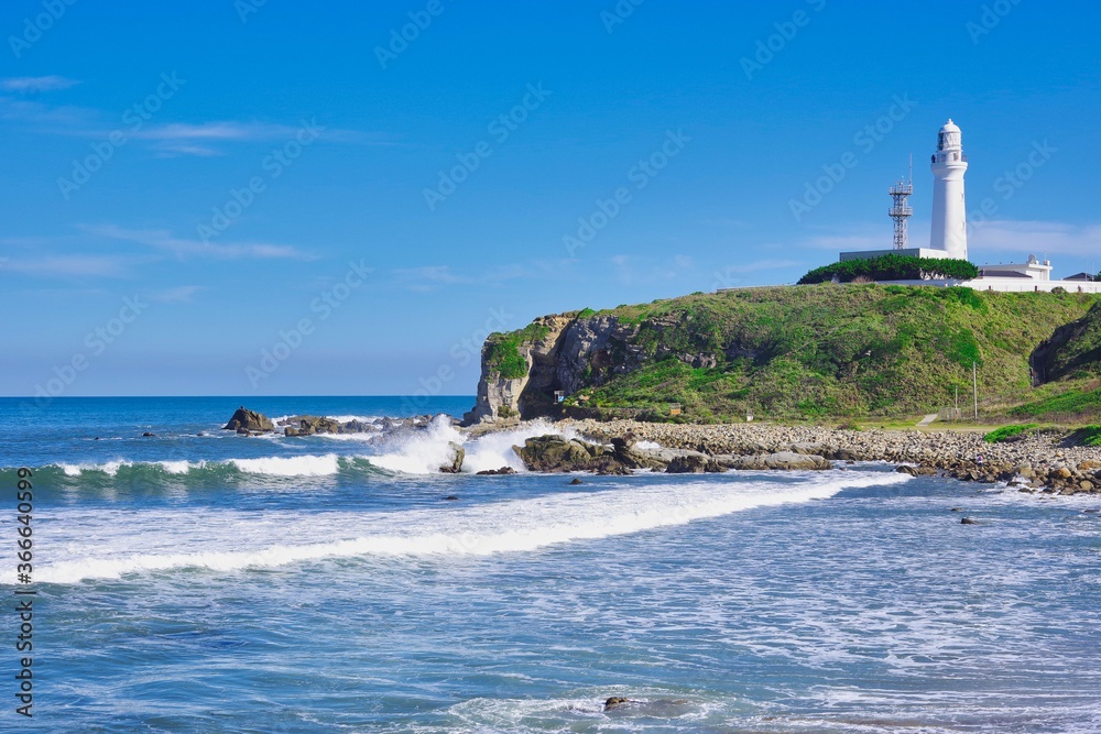 岬の灯台が見える海岸の景色