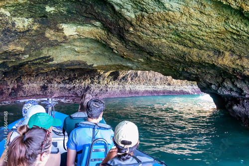 Sightseeing speedboat at the Benagil caves. View of Benagil cave from inside. Beautiful Natural Sea grottes with emerald water and little beaches in the Atlantic Ocean