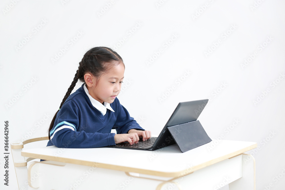 Portrait asian little child girl in school uniform using laptop on table isolated on white background, Studio shot Portrait asian little child girl in school uniform using laptop on table isolated on white background, Studio shot