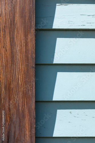 minimal, high contrast close up of blue siding and wood door trim