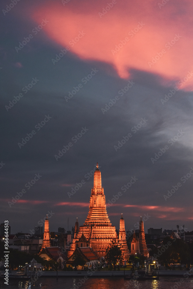 Fototapeta premium Templo Wat Arun al atardecer con el cielo lleno de nubes