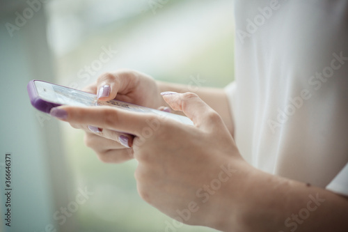Beautiful young woman hands holding a cell phone