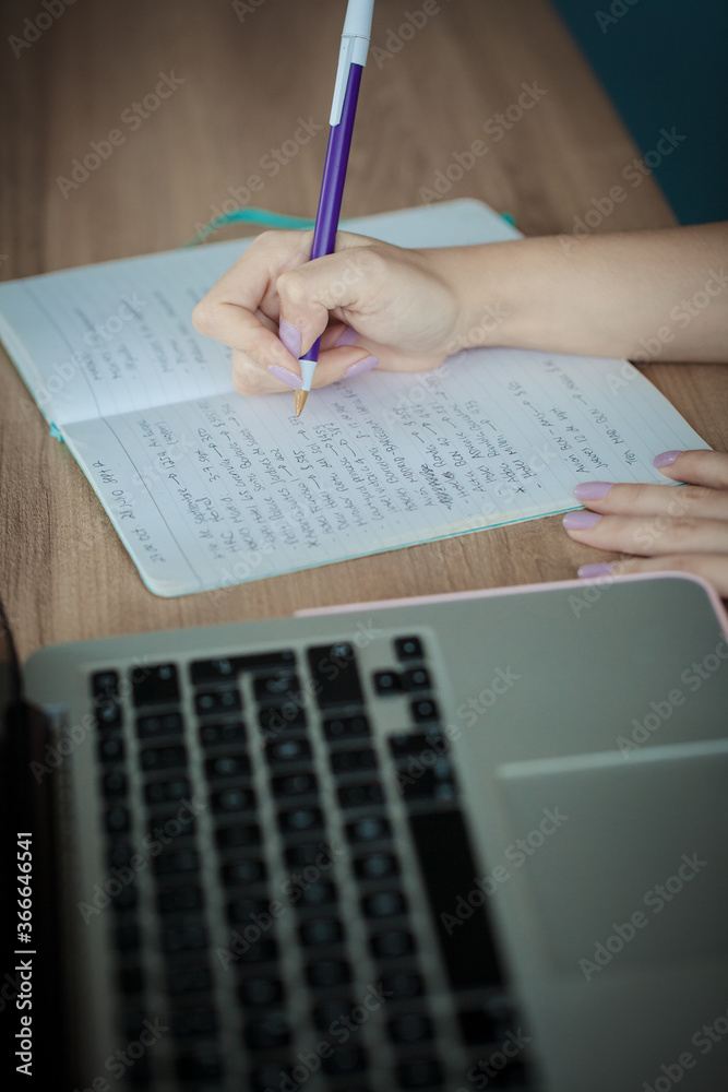 Close up of handwriting on paper, young female hands Close up of handwriting on paper, young female hands