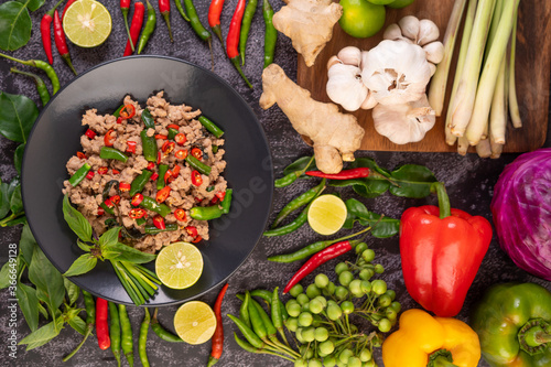 Stir-fried pork basil on banana leaves in a black dish.