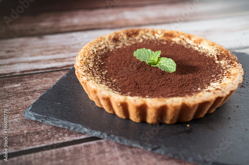 A top view of a delicious chocolate tart with mint on top