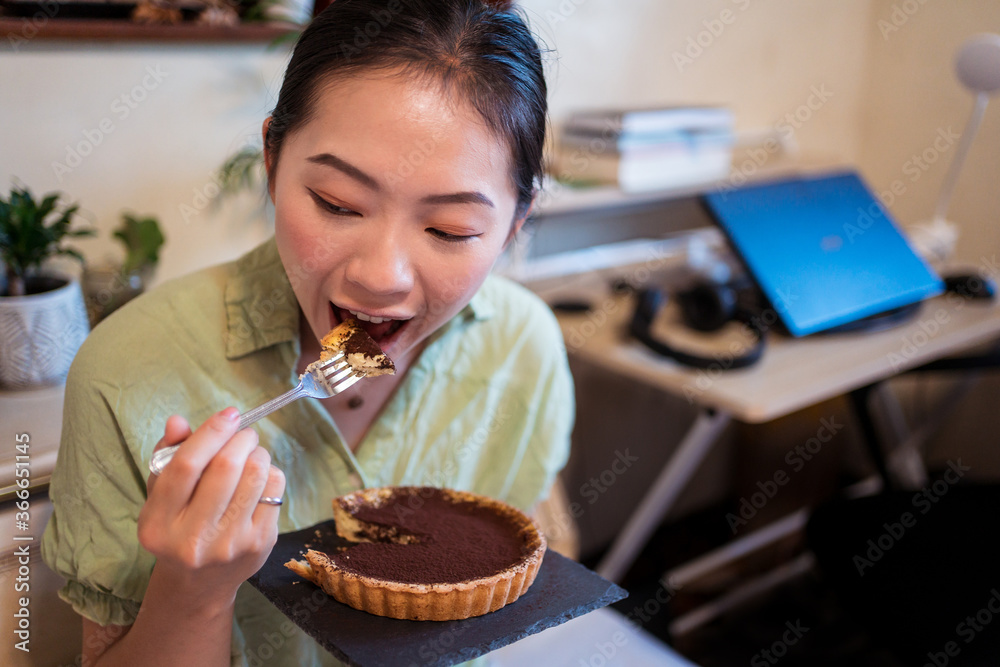 A top view of a delicious chocolate tart with mint on top being prepared by hand