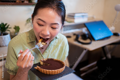A top view of a delicious chocolate tart with mint on top being prepared by hand