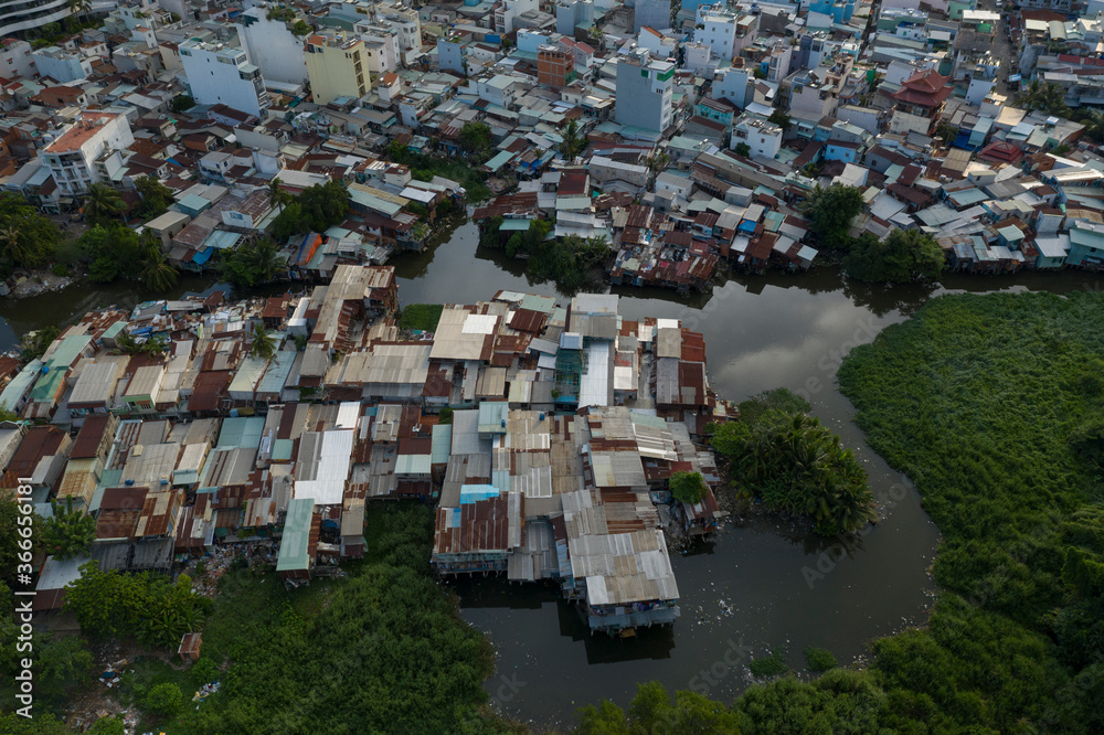 old residential and business area resembling a crowded shanty town built along a canal from aerial top down view