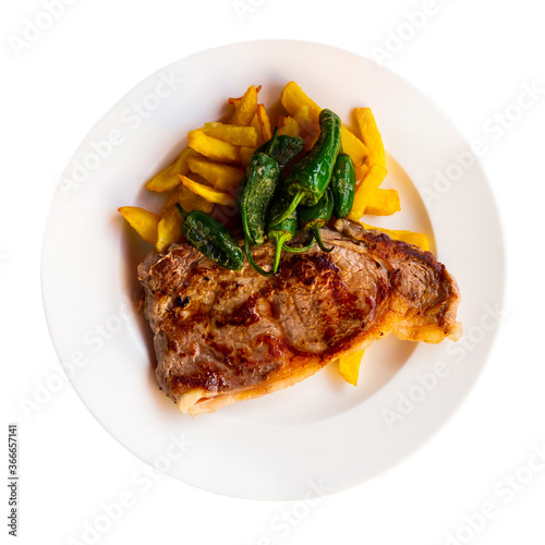 Tasty steak of beef sirloin served with French fried potatoes and baked jalapenos. Isolated over white background