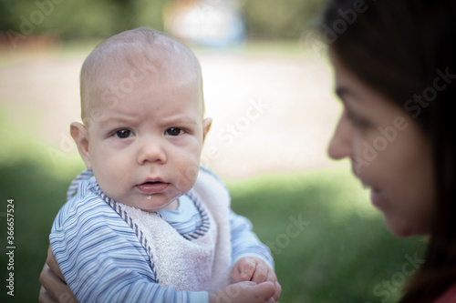 Bebé varón con su mamá en un parque haciendo muecas mirando hacia la cámara © Pablo Gazzola