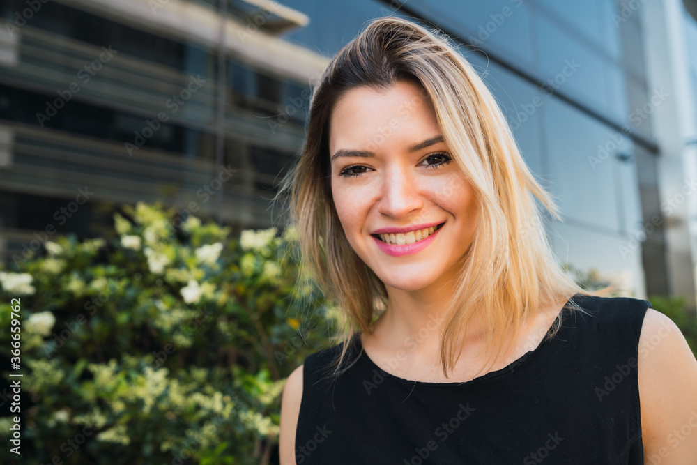 Fototapeta premium Business woman standing outside office buildings.