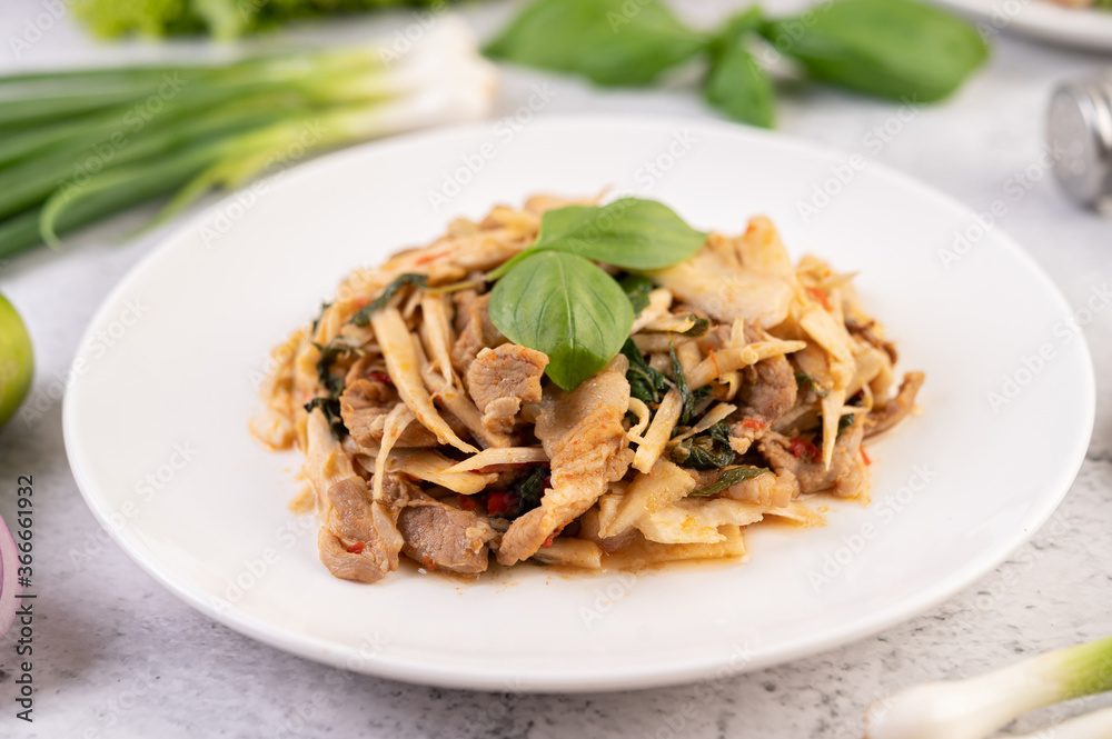 Bamboo shoot curry, add pork into a white dish. Bamboo shoot curry, add pork into a white dish.