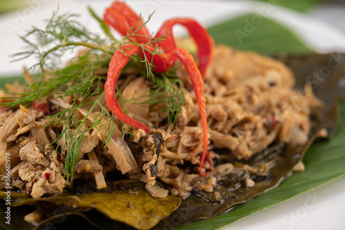 Mok bamboo shoots, put the pork on the banana leaf on a white plate. photo