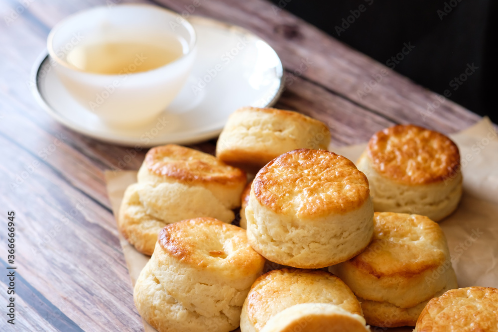 Close up group of fresh yummy tasty delicious Traditional British Scones and a cup of tea on wooden table  background. 