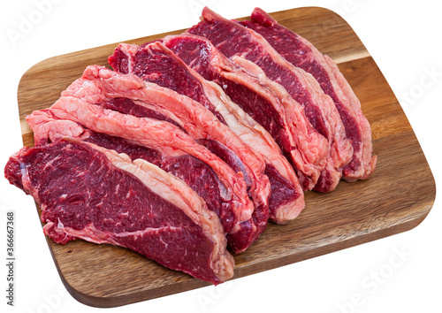Close up of raw veal on wooden surface, nobody. Isolated over white background
