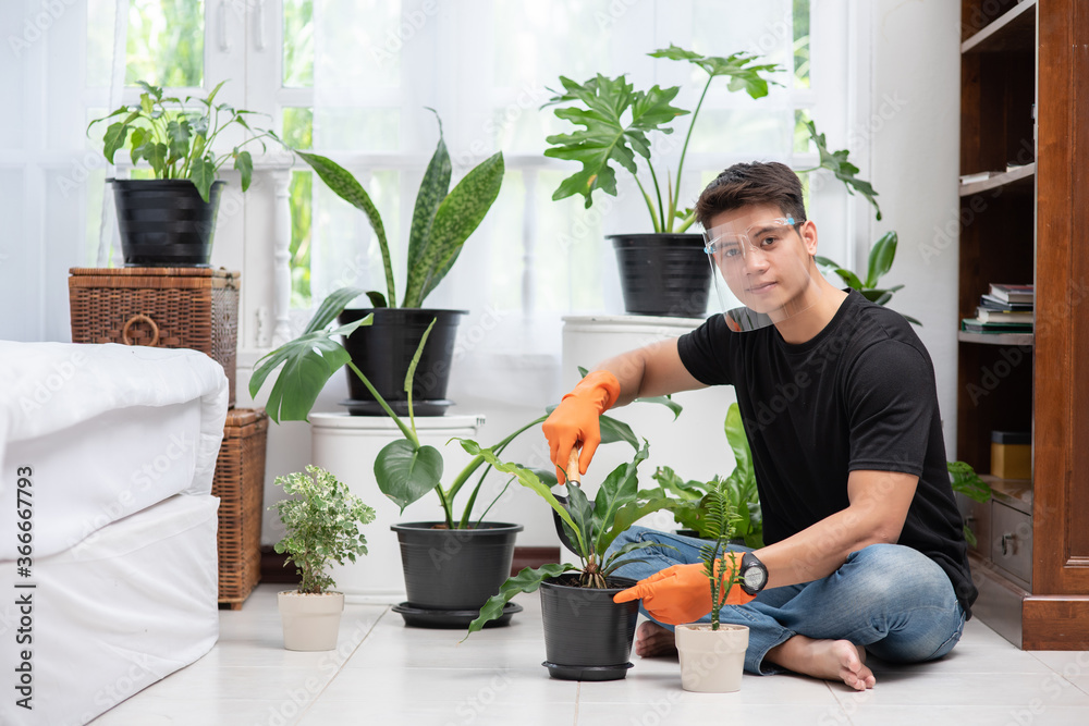 Men wearing orange gloves and planting trees indoors. Men wearing orange gloves and planting trees indoors.