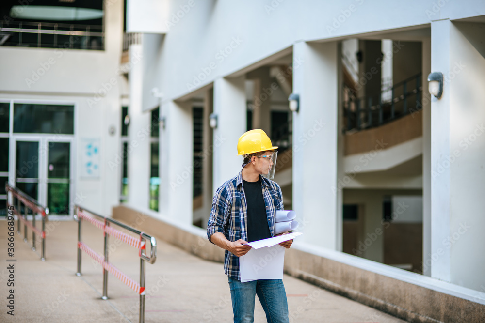 Architects hold the building plan and check the work. Architects hold the building plan and check the work.