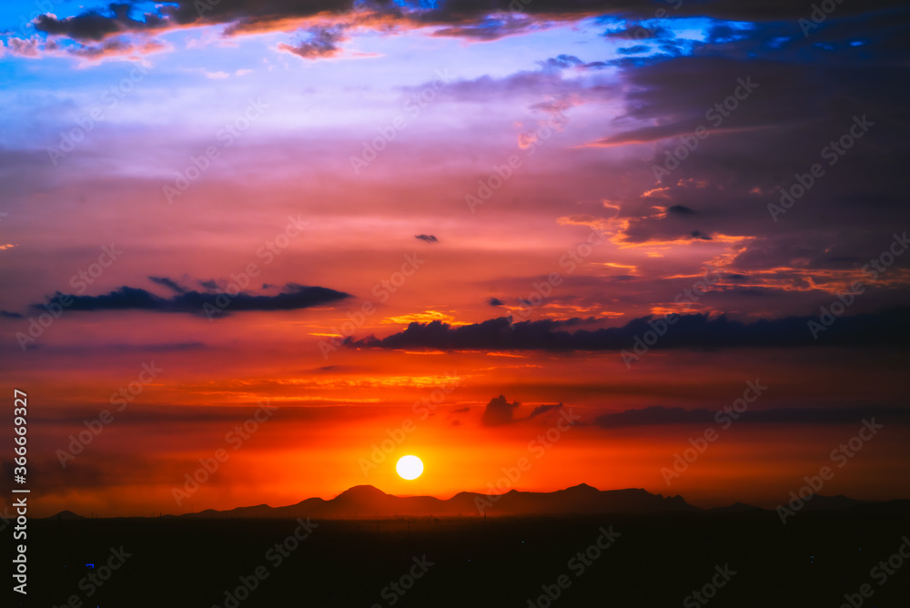 Fototapeta premium beautiful sunset with cloudy skies over the city and mountains 