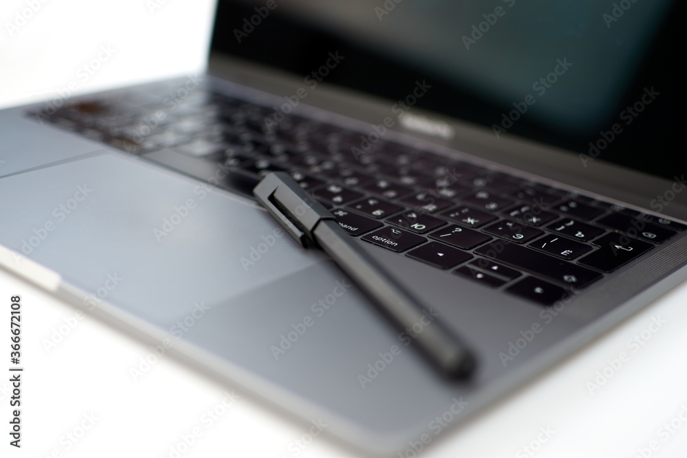 Close-up computer laptop keyboard, pen and pencil