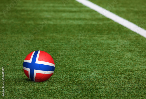 Bouvet Islands flag on ball at soccer field background. National football theme on green grass. Sports competition concept.