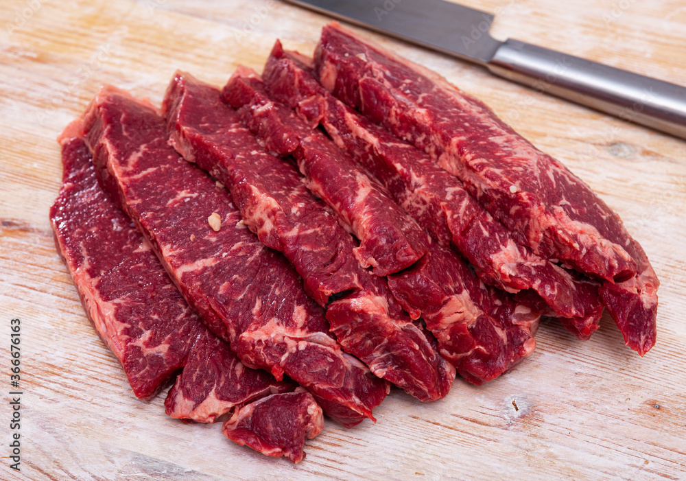 Obraz premium Raw juicy marbled beef entrecotes on wooden surface. Traditional deli meats