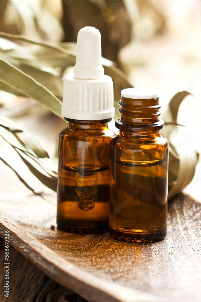 Eucalyptus essential oil and eucalyptus leaves on wooden table Eucalyptus essential oil and eucalyptus leaves on wooden table