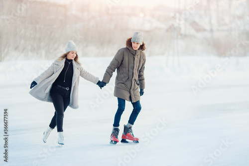 Fotografia Ice skating lover couple having fun on snow winter holidays